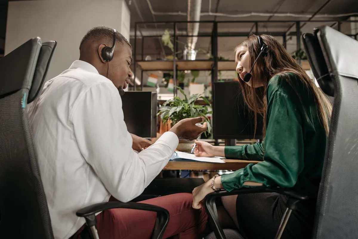 Deux personnes en conversation constructive au travail, échange de confiance et soutien.