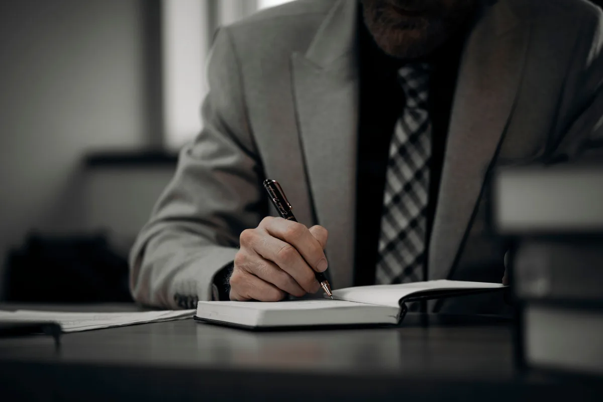 Personne écrivant ses valeurs et objectifs professionnels sur un carnet