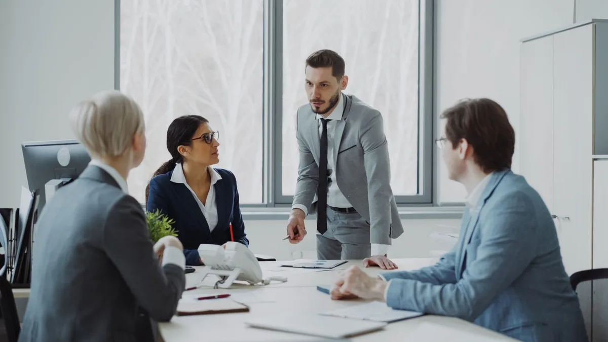 Dirigeants en réunion stratégique autour d'une table de conférence, analysant des documents