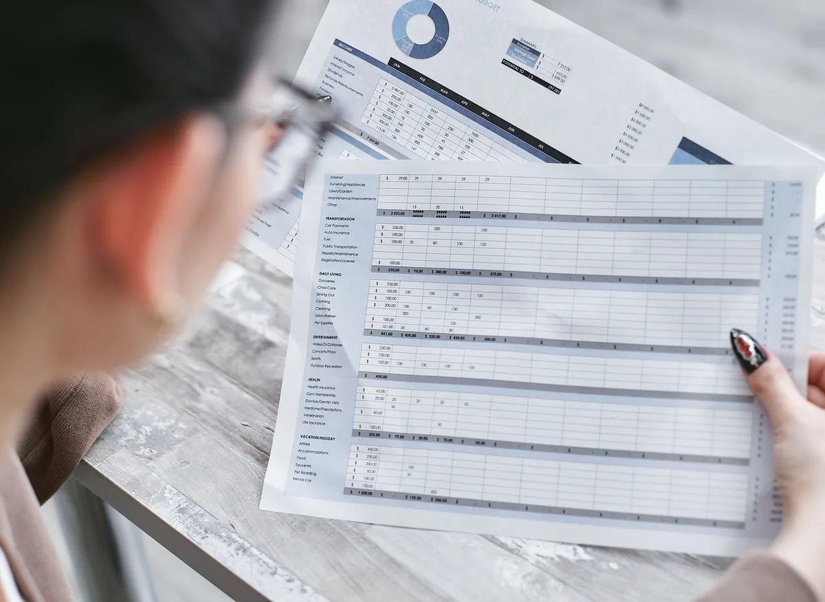 Documents financiers et tableau de bord de trésorerie sur un bureau d'entreprise.