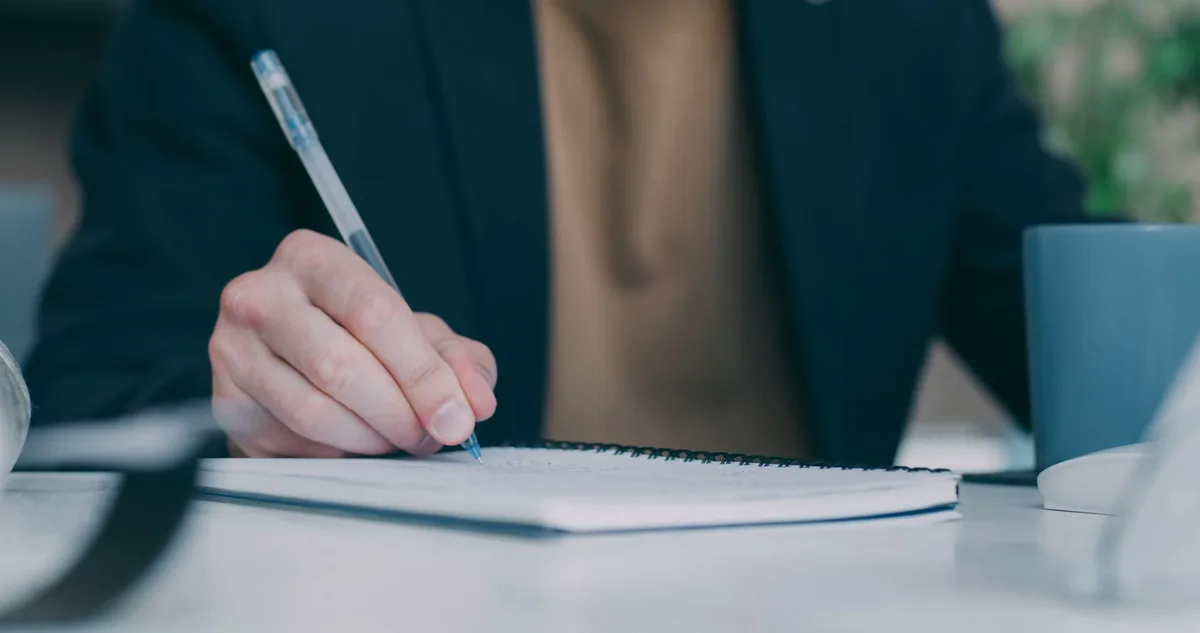 Manager notant ses réflexions et observations dans un journal pour développer son intelligence émotionnelle