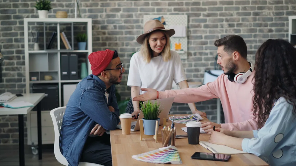 Une équipe réunie autour d'une table pour un point d'équipe structuré et régulier.