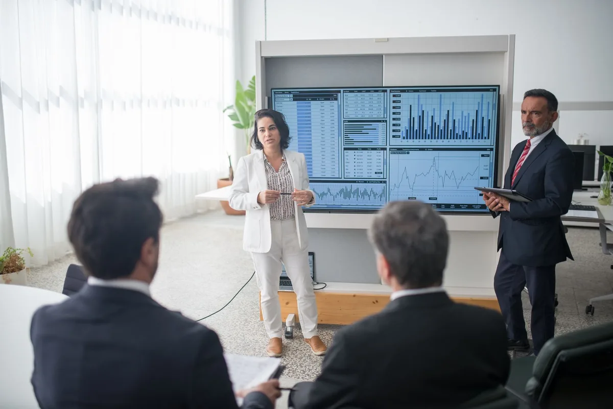 Professionnel présentant des données financières et graphiques à son équipe