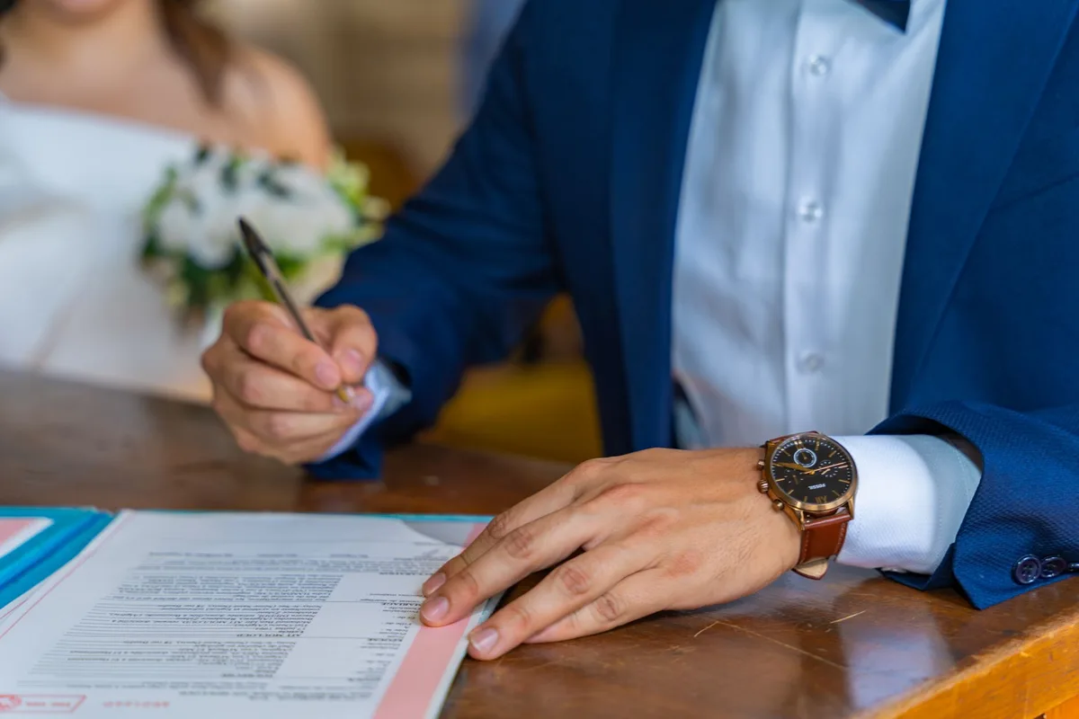 Deux personnes signant un document officiel de mariage ou Pacs