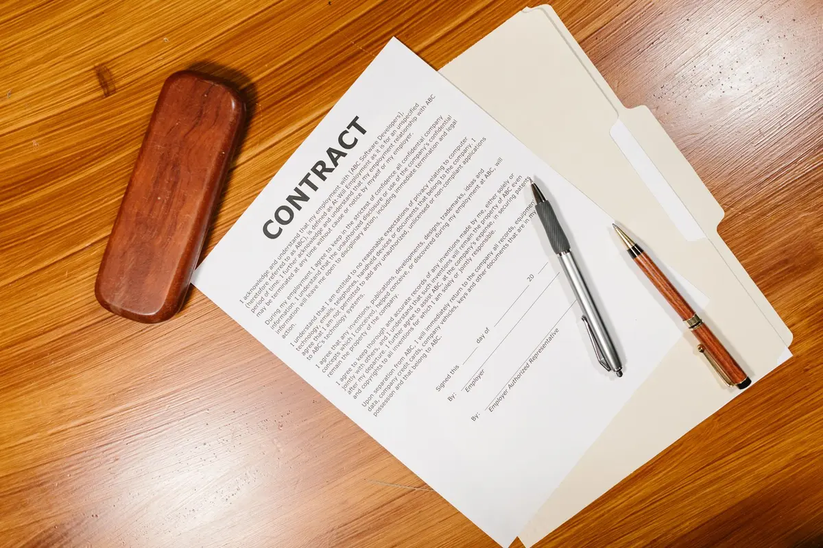 Documents contractuels et clauses de joint-venture étalés sur un bureau professionnel