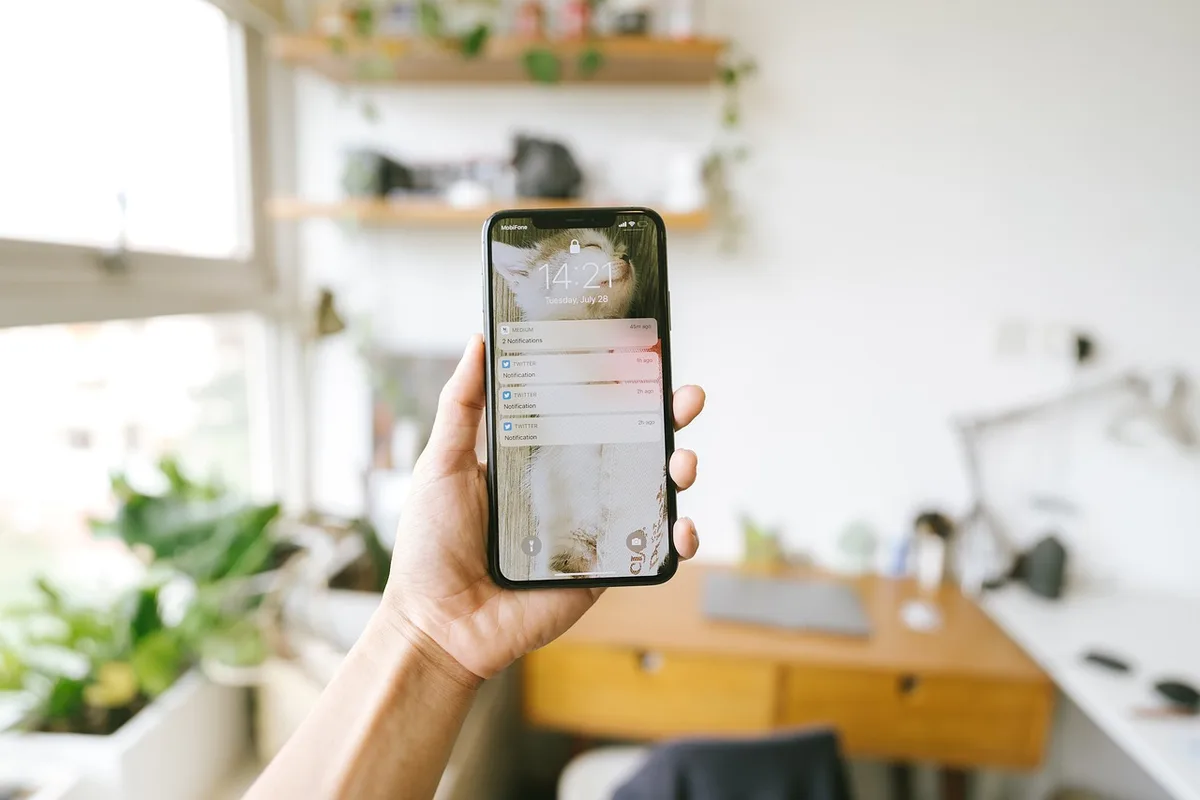 Main tenant un smartphone montrant une application de portefeuille numérique