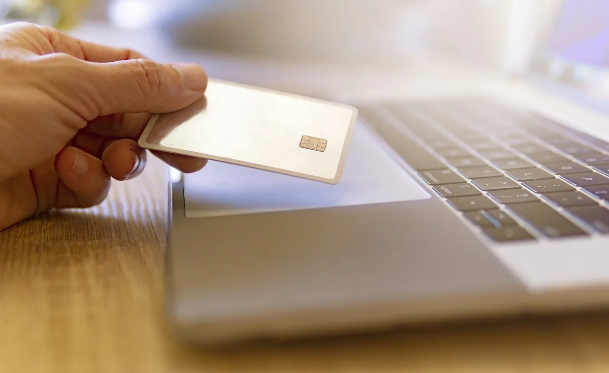 Commerçant près d'une caisse enregistreuse et d'un lecteur de cartes, illustrant les frictions de paiement