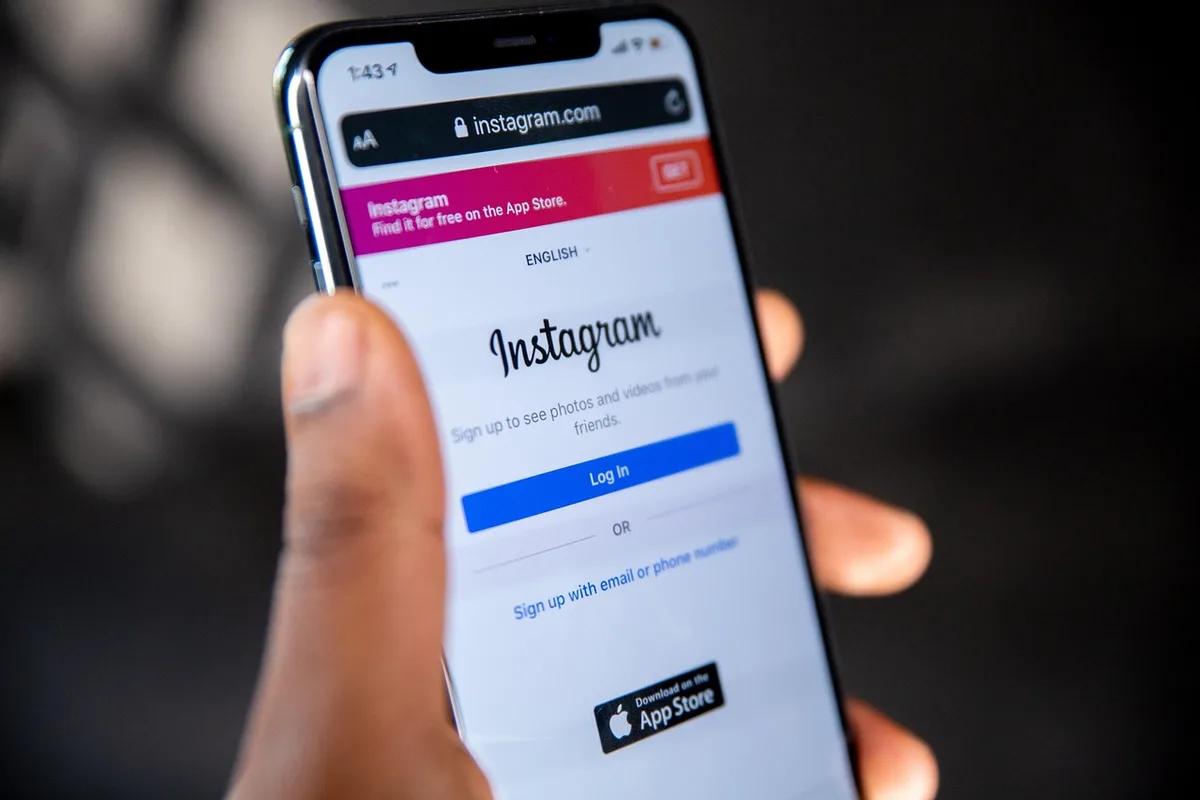 Mains manipulant un smartphone avec une application bancaire et un tableau de chiffres