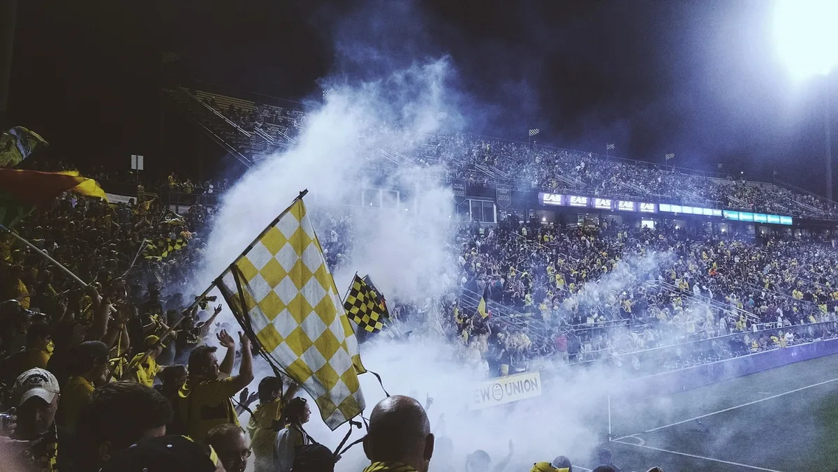 Public de rugby anonyme en tribune, rappelant le milieu sportif d'Aramburú