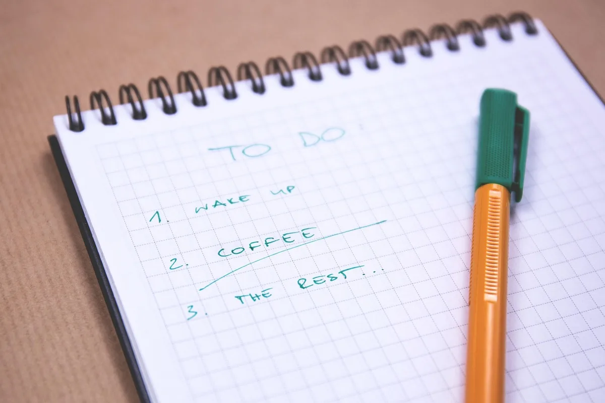 Main sur une checklist d'exportation et un ordinateur portable