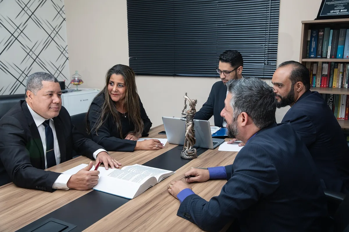 Main tenant un contrat imprimé au-dessus d'un bureau pour préparation juridique
