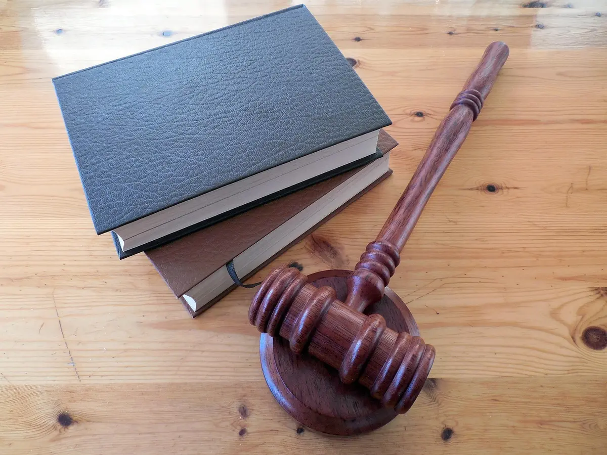 Documents et dossier juridique ouverts sur une table d'audience