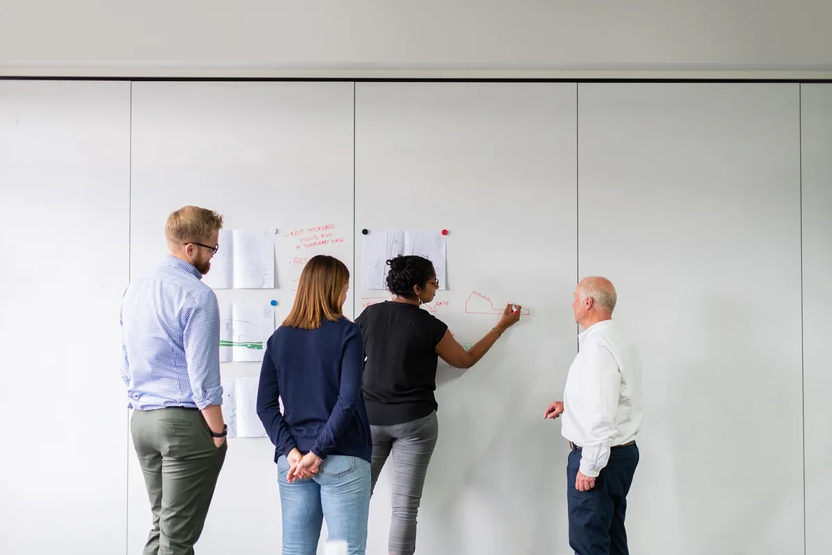 Équipe travaillant sur une stratégie de tarification avec tableau blanc