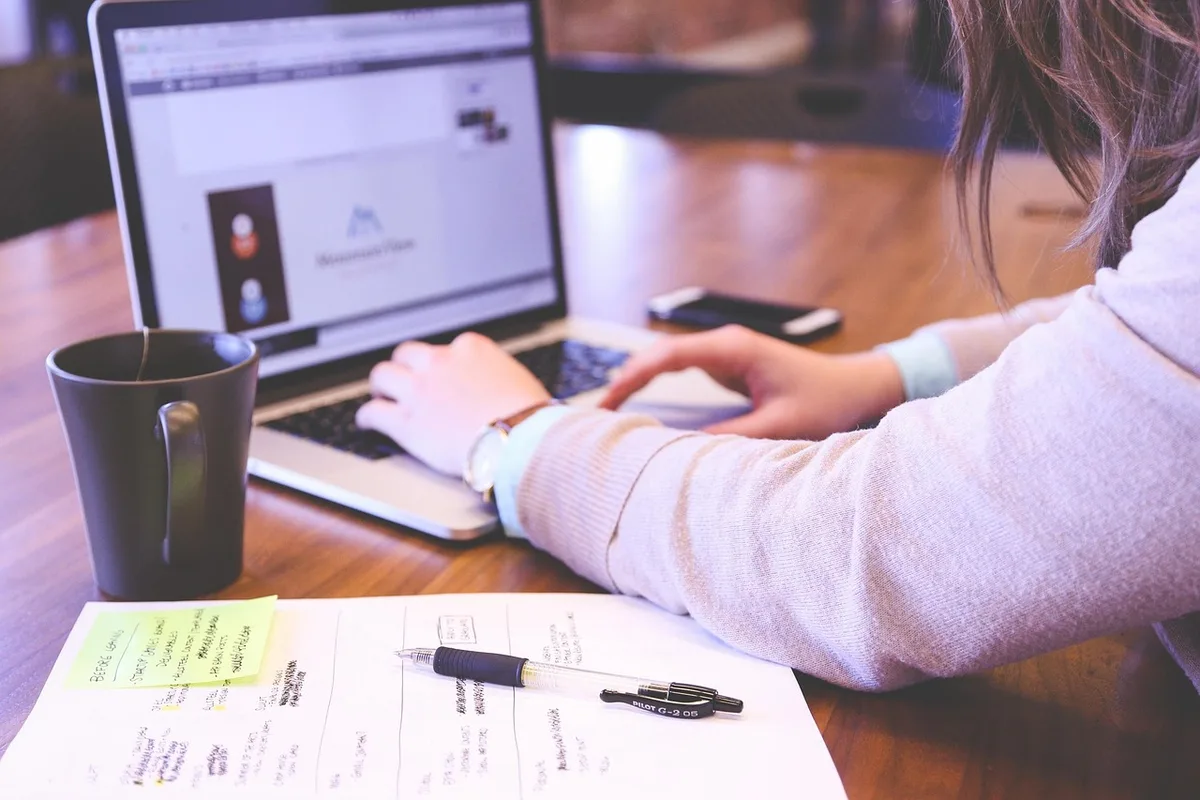 Personne regardant un smartphone au bureau, multiplication des notifications